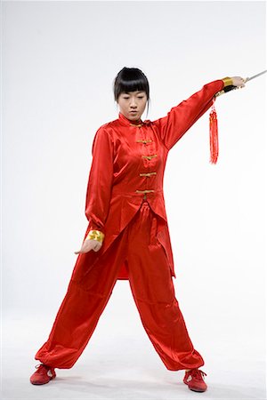 a woman in red dress practicing Chinese Kungfu with a sword Foto de stock - Sin royalties Premium, Código: 642-02006535