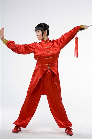 a woman in red dress practicing Chinese Kungfu with a sword Foto de stock - Sin royalties Premium, Código: 642-02006536