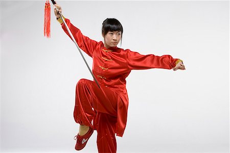 a woman in red dress practicing Chinese Kungfu with a sword Foto de stock - Sin royalties Premium, Código: 642-02006540