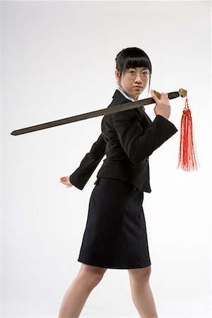 a business woman practicing Chinese Kungfu with a sword Foto de stock - Sin royalties Premium, Código: 642-02006555
