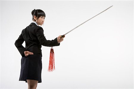 a business woman practicing Chinese Kungfu with a sword Foto de stock - Sin royalties Premium, Código: 642-02006556