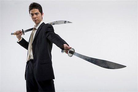 a business man practicing Chinese Kungfu with two swords Stock Photo - Premium Royalty-Free, Code: 642-02006561