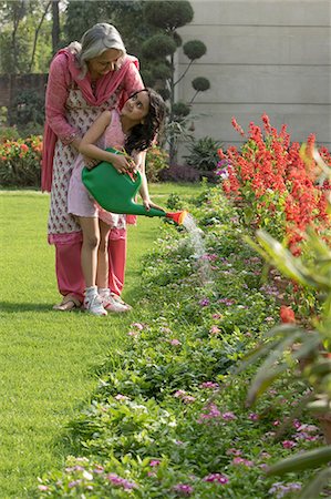 Grandmother with granddaughter (4-5) using watering can Stock Photo - Premium Royalty-Free, Code: 655-08357034