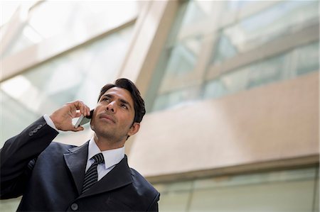 simsearch:614-06718128,k - India, Businessman in suit talking on mobile phone outside office building Stock Photo - Premium Royalty-Free, Code: 655-08357076