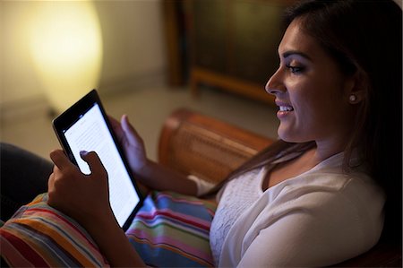 Singapore, Side view of woman looking using tablet at night Stock Photo - Premium Royalty-Free, Code: 655-08357191