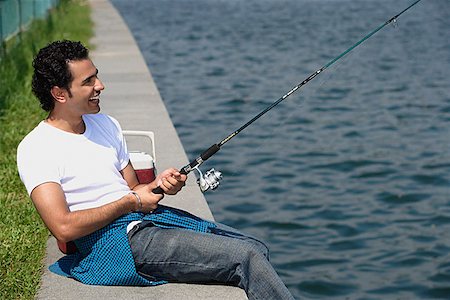 Young man fishing in river Stock Photo - Premium Royalty-Free, Code: 655-01781528