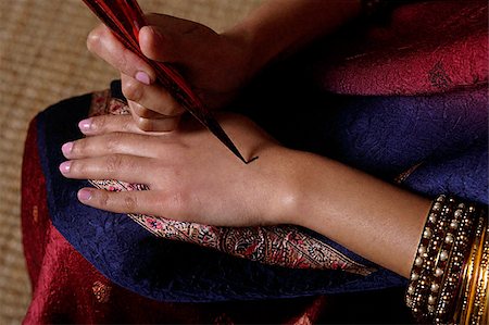 singapore traditional costume lady - Indian woman painting hand with henna Stock Photo - Premium Royalty-Free, Code: 655-02375845