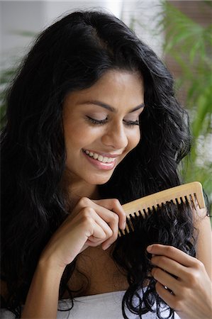 exotic outdoors - Indian woman smiling and combing her hair. Stock Photo - Premium Royalty-Free, Code: 655-03241679