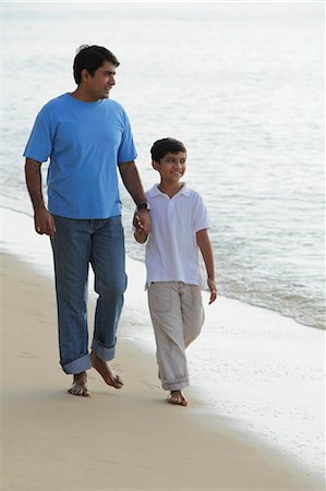 Father and son holding hands and walking down the beach. Stock Photo - Premium Royalty-Free, Code: 655-03457888
