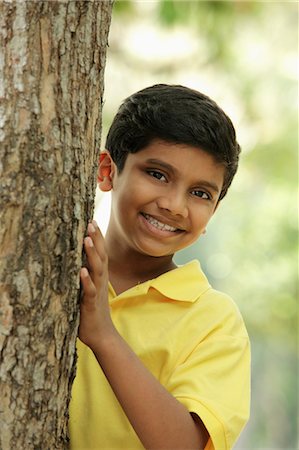 Young boy peeking out from behind a tree Stock Photo - Premium Royalty-Free, Code: 655-03457927