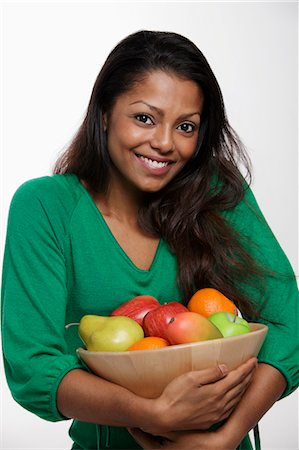 Woman wearing green top holding bowl of fruit Stock Photo - Premium Royalty-Free, Code: 655-03457921