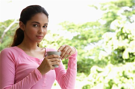 Young woman holding cup looking at camera Stock Photo - Premium Royalty-Free, Code: 655-03457940