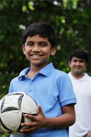 soccer dad - Young boy holding ball while father stands behind him Stock Photo - Premium Royalty-Free, Code: 655-03457970