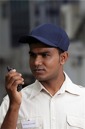 Security guard talking into walkie talkie Stock Photo - Premium Royalty-Free, Code: 655-03457995