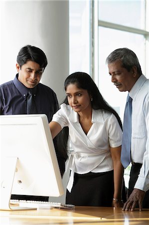 simsearch:655-03458001,k - Indian woman looking at a computer with male colleagues Stock Photo - Premium Royalty-Free, Code: 655-03458015