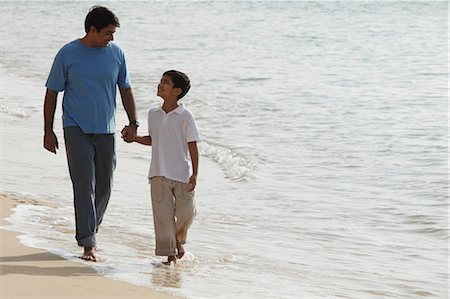 Father and son holding hands and walking on beach Stock Photo - Premium Royalty-Free, Code: 655-03458062