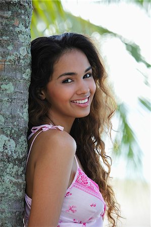 young woman leaning next to tree and smiling Stock Photo - Premium Royalty-Free, Code: 655-03519580