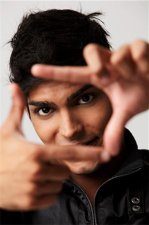 head shot of young man making a frame with his fingers Stock Photo - Premium Royalty-Free, Code: 655-03519714