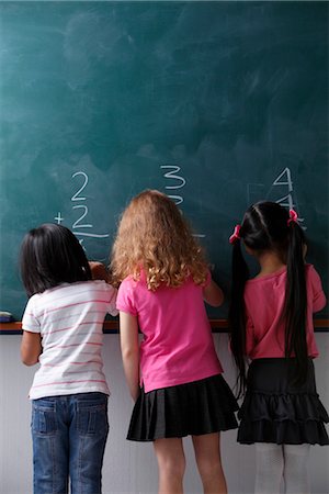 elementary school - three girls writing on chalk view Stock Photo - Premium Royalty-Free, Code: 656-04926481