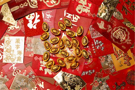 Gold money, ingot scattered on red packets or Hong Baos Stock Photo - Premium Royalty-Free, Code: 656-04926550