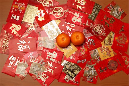 Man different Hong Baos, red envelopes with oranges. Stock Photo - Premium Royalty-Free, Code: 656-04926597