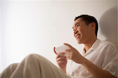 simsearch:656-03241003,k - Singapore, Young man texting on sofa Stock Photo - Premium Royalty-Free, Code: 656-08349895