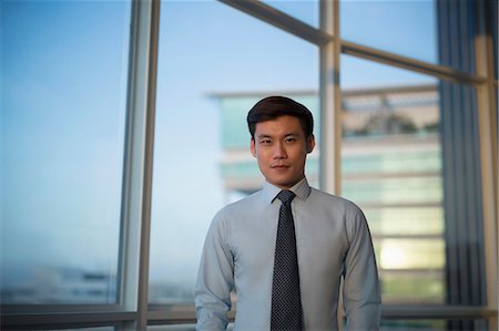 simsearch:656-03241003,k - Singapore, Indoor portrait of businessman standing in front of window Stock Photo - Premium Royalty-Free, Code: 656-08349905