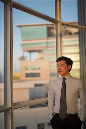 simsearch:656-03241003,k - Singapore, Businessman standing at window in office Stock Photo - Premium Royalty-Free, Code: 656-08349902