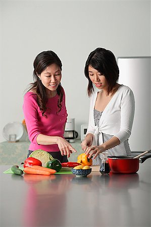 friends cooking inside - Mother guiding daughter in preparing a meal Stock Photo - Premium Royalty-Free, Code: 656-01765223