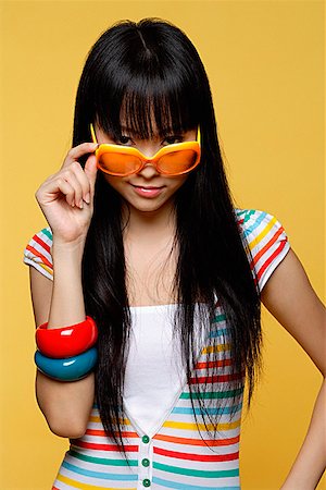 Young woman peering over sunglasses Stock Photo - Premium Royalty-Free, Code: 656-01765335