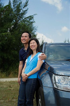 simsearch:841-02720357,k - Man and woman leaning against SUV arm around woman Stock Photo - Premium Royalty-Free, Code: 656-01765350