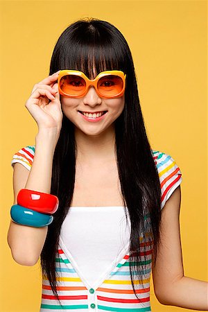 Young woman wearing big sunglasses, smiling Stock Photo - Premium Royalty-Free, Code: 656-01765386