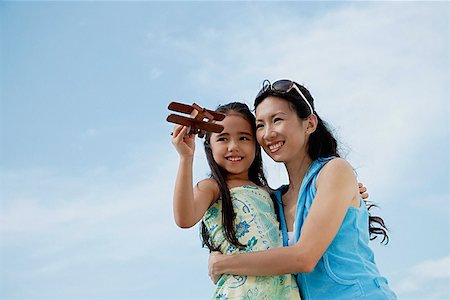 Mother and daughter flying wooden airplane, mother holding daughter Stock Photo - Premium Royalty-Free, Code: 656-01765534