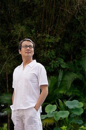 self satisfaction - Man in white shirt and pants, standing in garden Stock Photo - Premium Royalty-Free, Code: 656-01765714