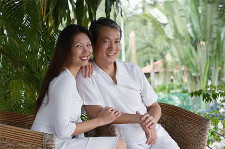 simsearch:841-02720357,k - Couple sitting on rattan chairs, looking at camera, smiling Stock Photo - Premium Royalty-Free, Code: 656-01765805