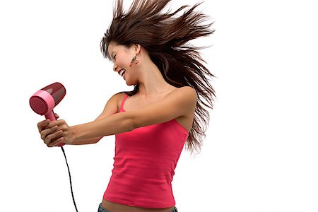 Young woman blow drying hair with hair flying Stock Photo - Premium Royalty-Free, Code: 656-01765842