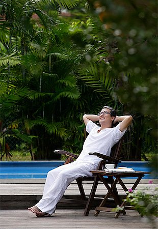 people relaxing in pool chairs - Mature man sitting outdoors, hands behind head, looking up Stock Photo - Premium Royalty-Free, Code: 656-01765931