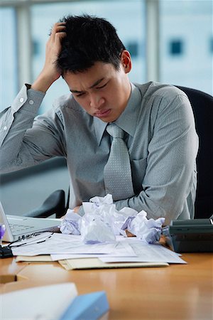 straining (overexertion) - A man looks stressed as he works at his desk Foto de stock - Sin royalties Premium, Código: 656-01766202