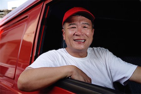 A man in a red van smiles at the camera Foto de stock - Sin royalties Premium, Código: 656-01766548