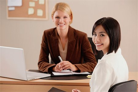 Two female colleagues smile at the camera together Stock Photo - Premium Royalty-Free, Code: 656-01766542