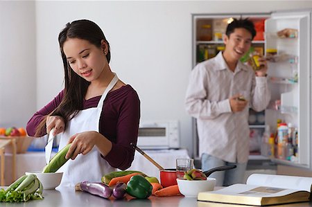 friends cooking inside - Young couple cooking in the kitchen Stock Photo - Premium Royalty-Free, Code: 656-01766914