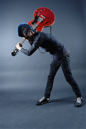 simsearch:656-03241003,k - Man with mohawk, holding guitar, over shoulder, bending down Stock Photo - Premium Royalty-Free, Code: 656-01768022