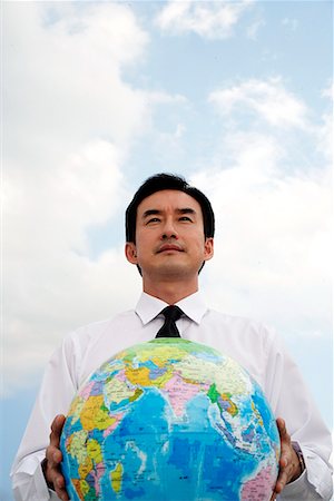 Businessman standing and holding globe Stock Photo - Premium Royalty-Free, Code: 656-01768784