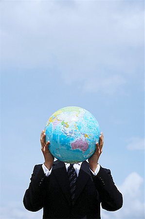 Businessman holding globe in front of his face Stock Photo - Premium Royalty-Free, Code: 656-01768876