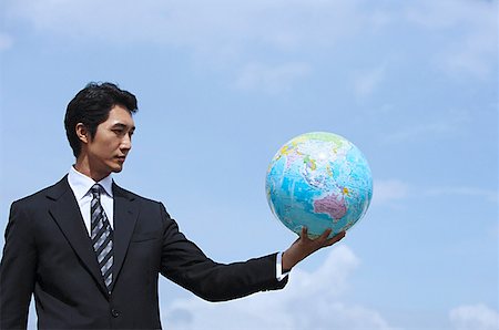 Businessman holding globe, arms outstretched Stock Photo - Premium Royalty-Free, Code: 656-01768877