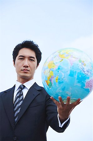 Businessman holding globe towards camera Stock Photo - Premium Royalty-Free, Code: 656-01768879