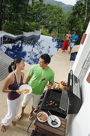 pool party - Couple grilling food over barbeque Stock Photo - Premium Royalty-Free, Code: 656-01770180