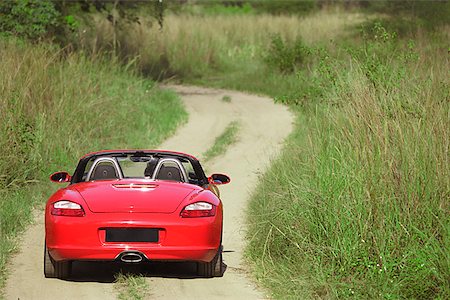 Red sports car on rural road Stock Photo - Premium Royalty-Free, Code: 656-01771407