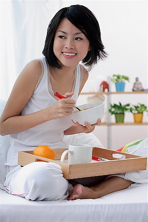 Young woman having breakfast in bed Stock Photo - Premium Royalty-Free, Code: 656-01773536