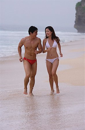 fitness asian couple - Couple running along beach Stock Photo - Premium Royalty-Free, Code: 656-01773581
